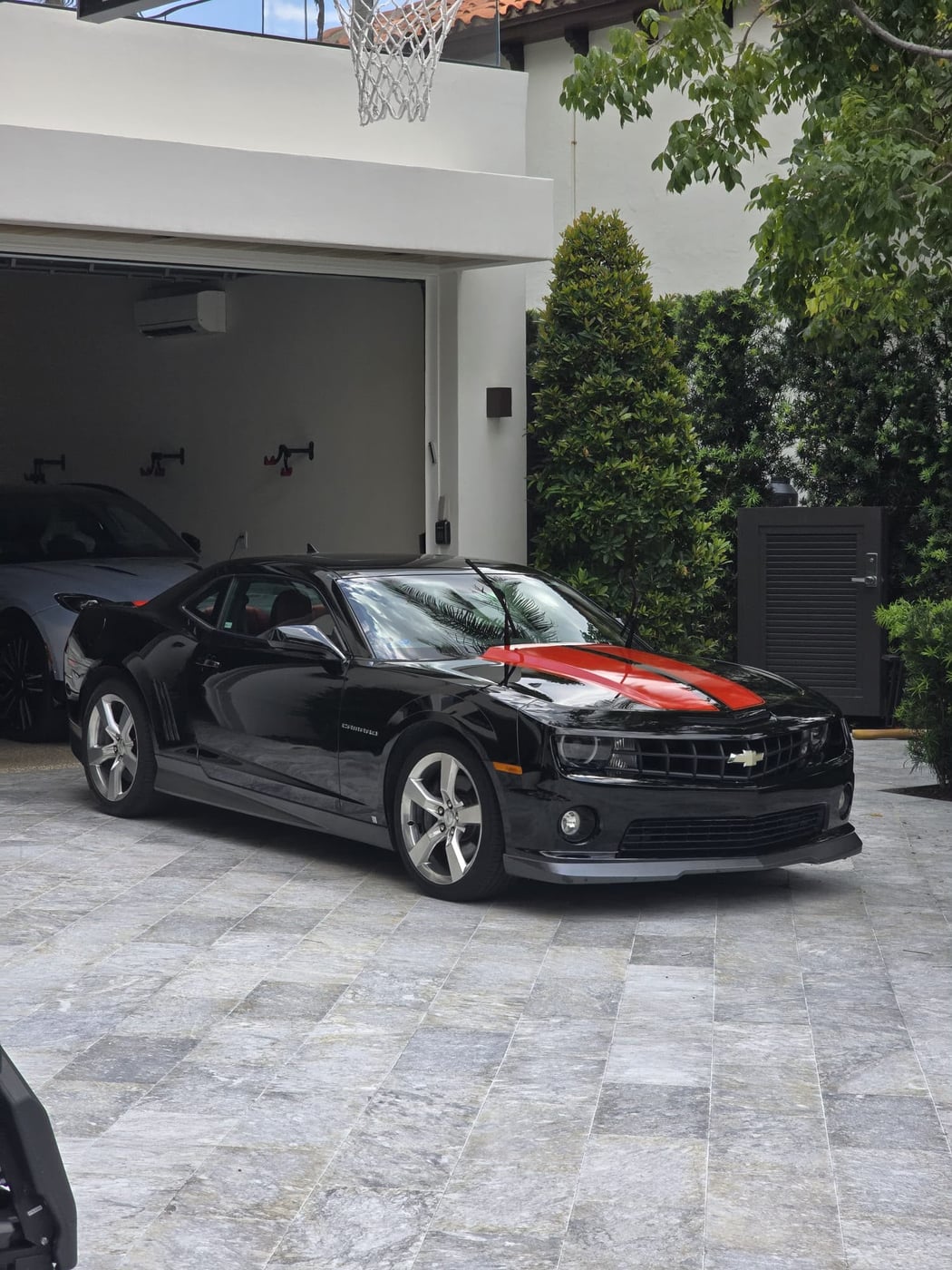 Freshly detailed black Camaro in a Miami driveway